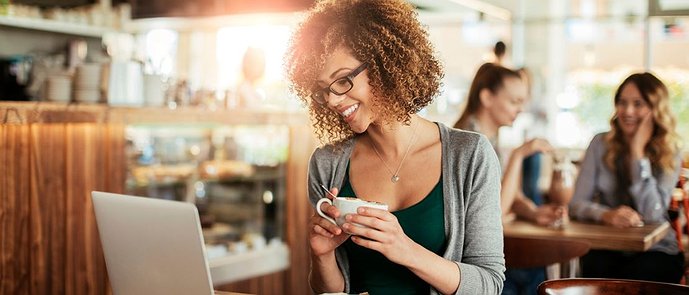 A woman in a cafe with a laptop